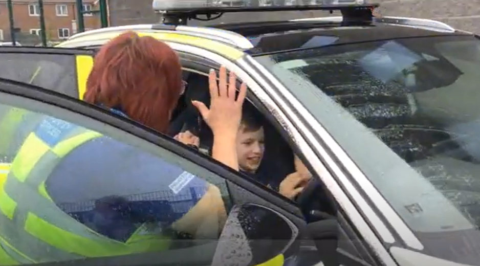 pupils sits in the driver seat of a police car and is chatted to by an officer
