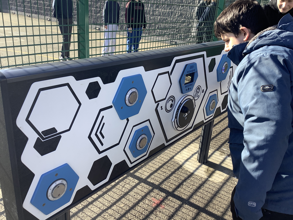 pupil playing on the new game play panel outside